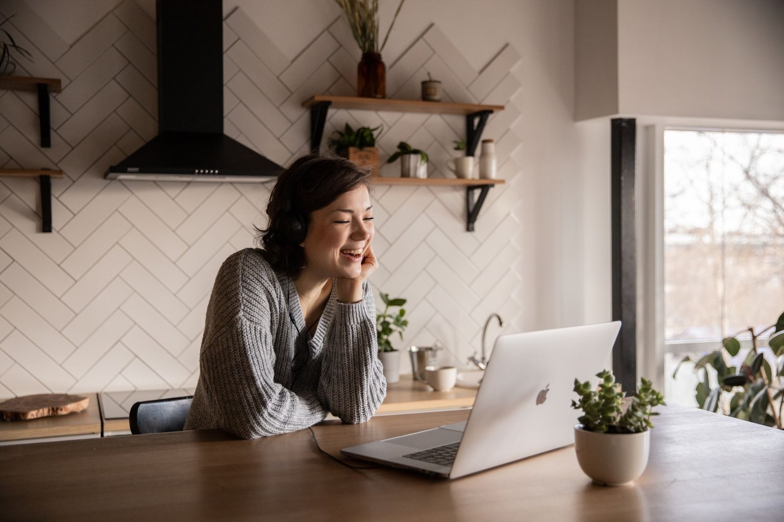 A woman speaking by video from her kitchen table